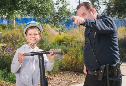 Policial conversando com um menino em frente a uma scooter – ideal para praticar perguntas indiretas em inglês.